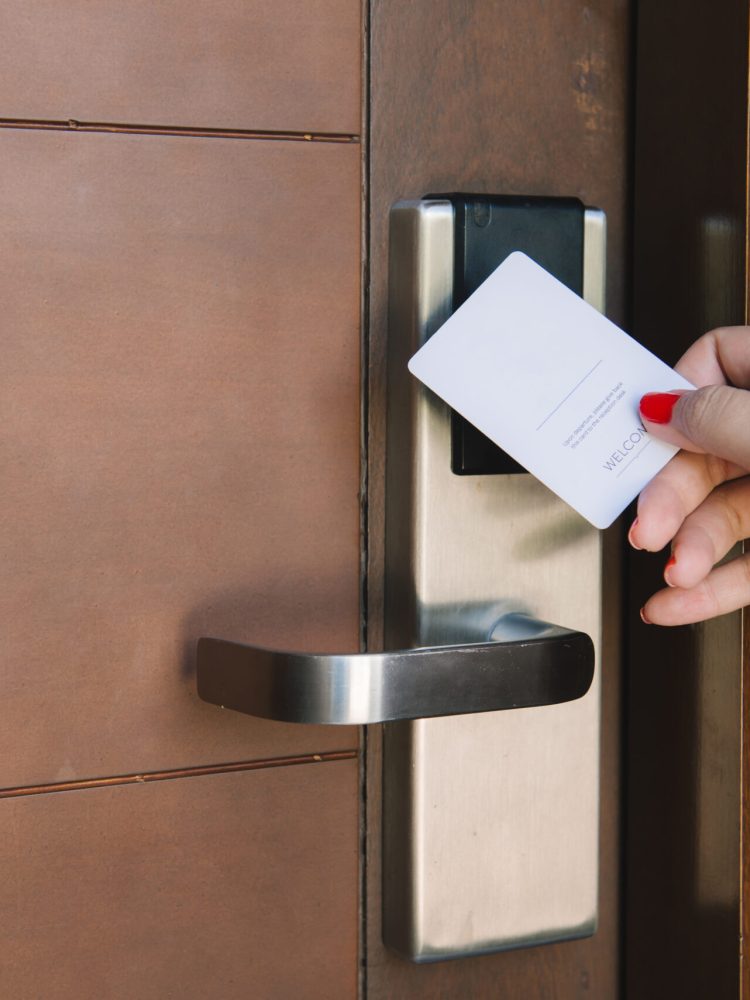 Young woman opening hotel room electronic lock with key card