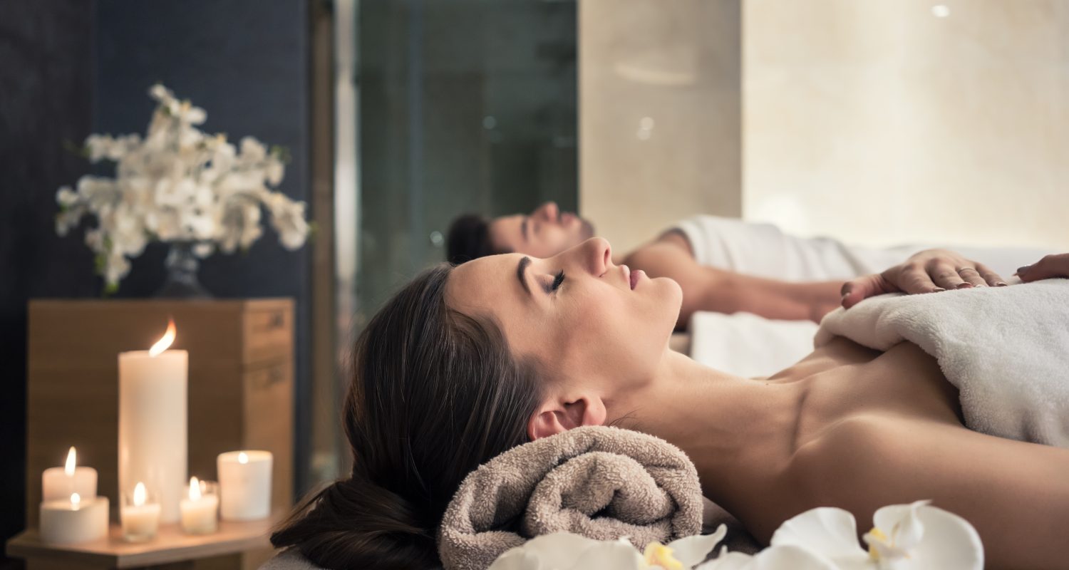 Young man and woman lying down on massage beds at Asian luxury spa and wellness center